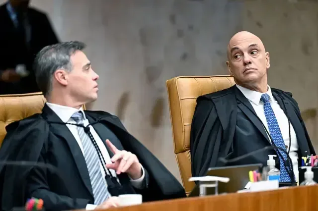 Ministro André Mendonça e Alexandre de Moraes sentados um ao lado do outro no plenário do STF